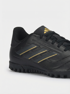 Black soccer shoe with gold stripes on a white background