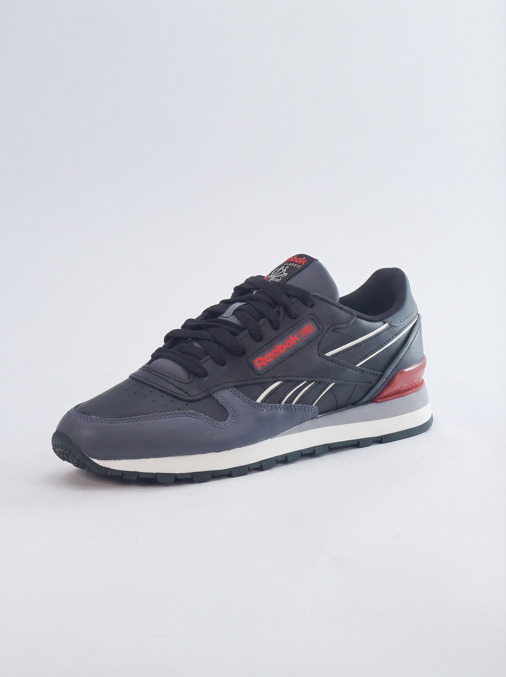 Navy blue sneaker with red accents on a light gray background