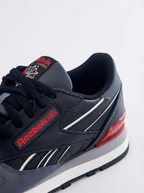 Navy Reebok sneaker with red accents on a white background