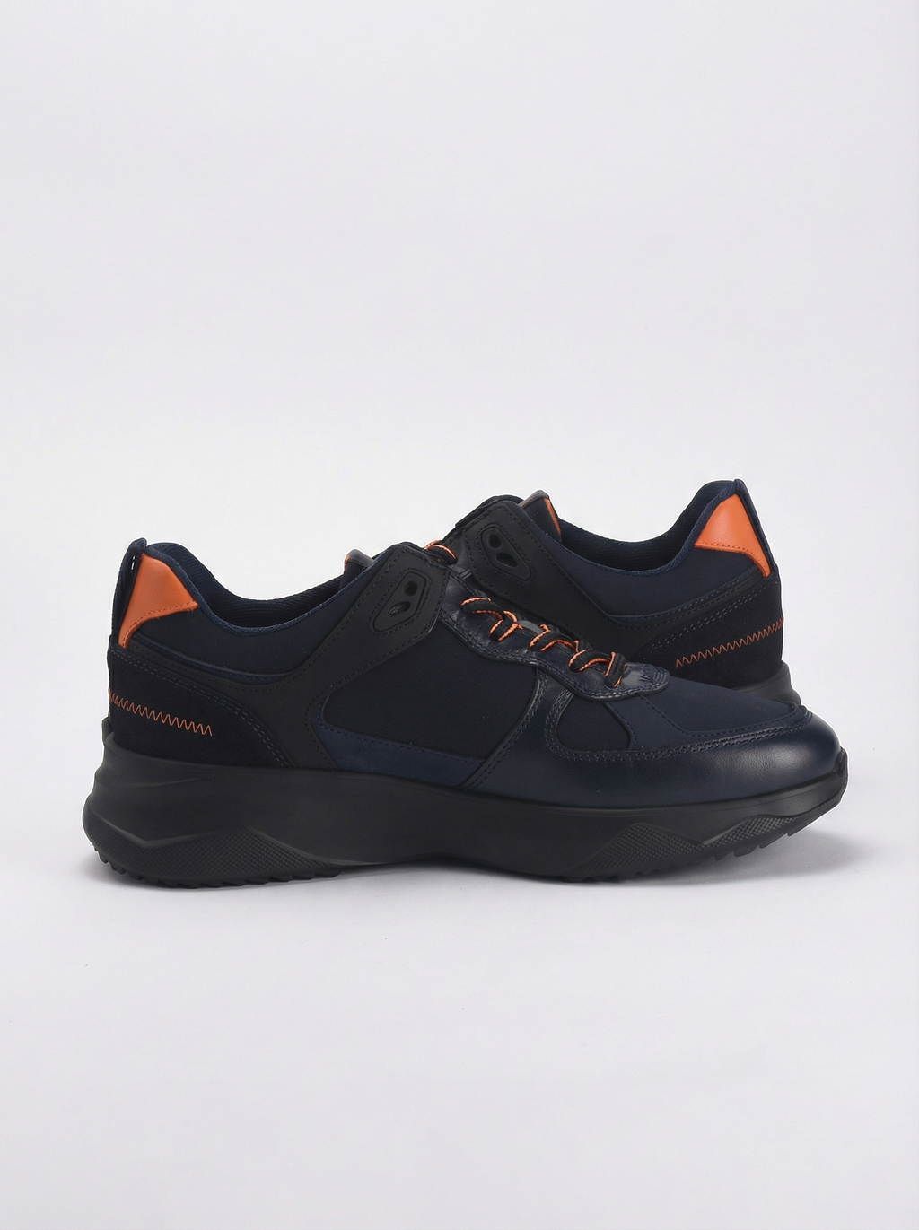 Black sneaker with orange accents on a light gray background