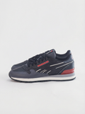 Navy blue sneaker with red accents on a light gray background