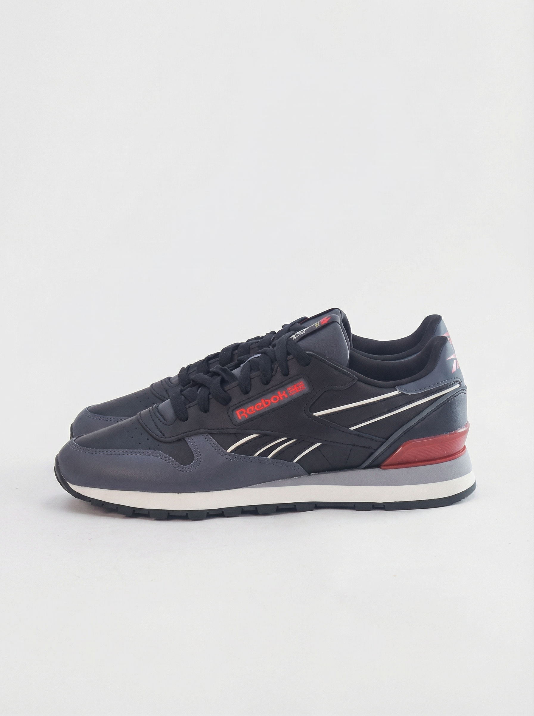 Navy blue sneaker with red accents on a light gray background